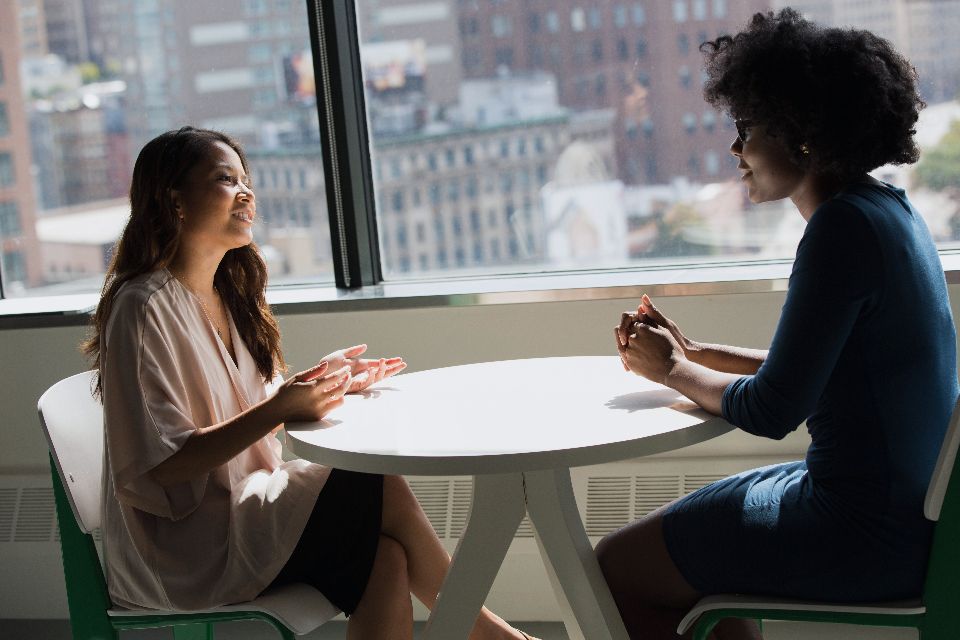 A Harbiva advisor meeting with a client at a table by a bright window